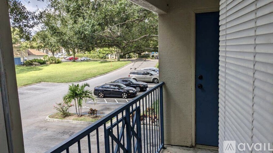 A balcony view of a parking lot with cars and trees.
