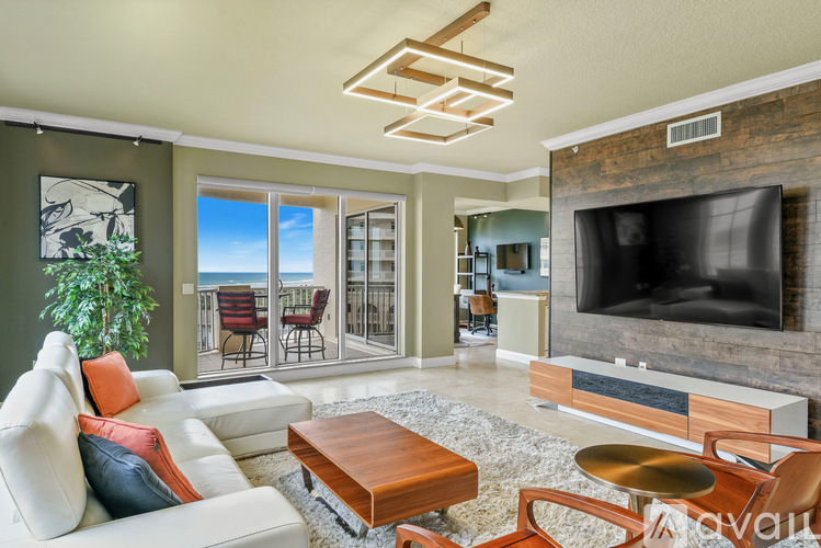 A living room with a white couch and a flat screen TV.