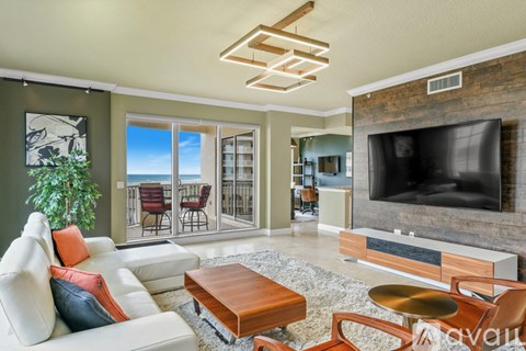 A living room with a white couch and a flat screen TV.