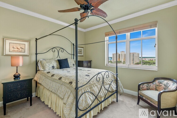 A bedroom with a four poster bed and a ceiling fan.