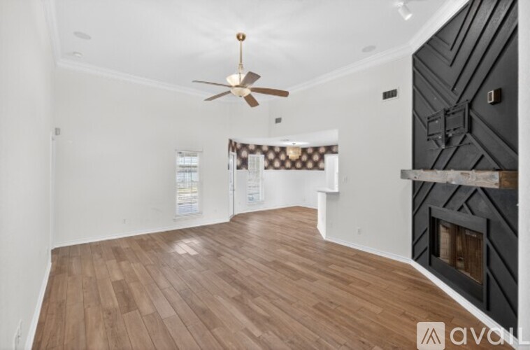 A room with wooden flooring and a ceiling fan.