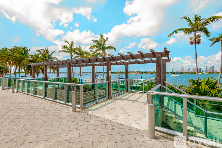 A walkway with a railing and palm trees.