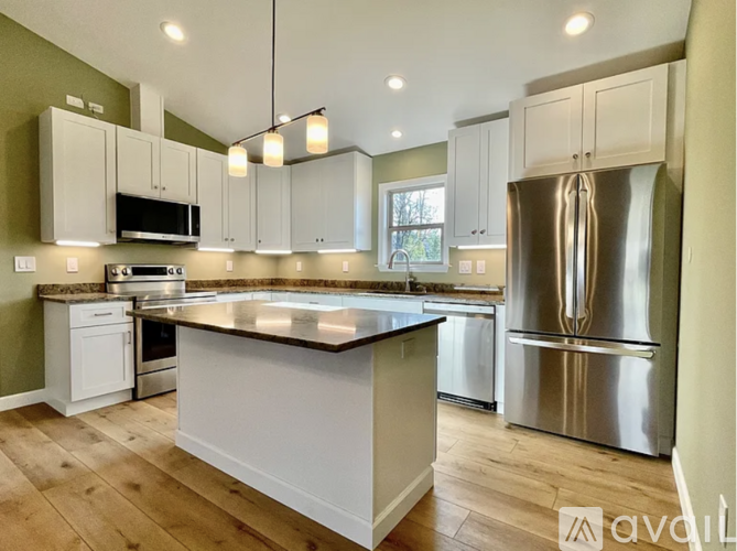 A kitchen with a large island and stainless steel appliances.