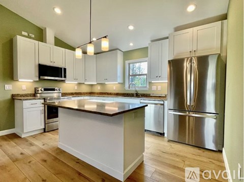 A kitchen with a large island and stainless steel appliances.