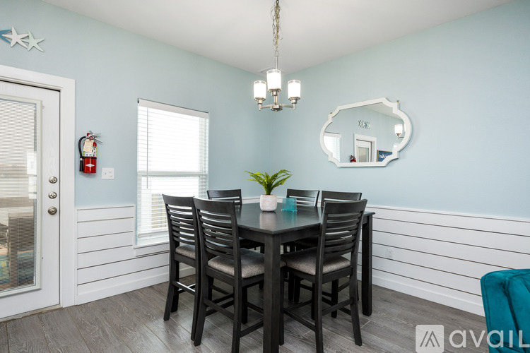 A dining room with a table and chairs.