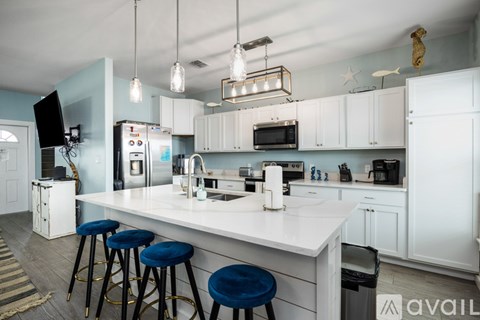 A kitchen with a white counter and blue stools.