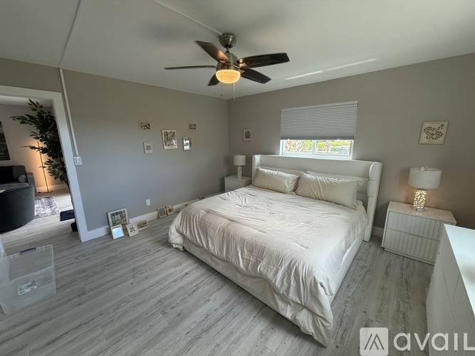 A bedroom with a large bed and a ceiling fan.