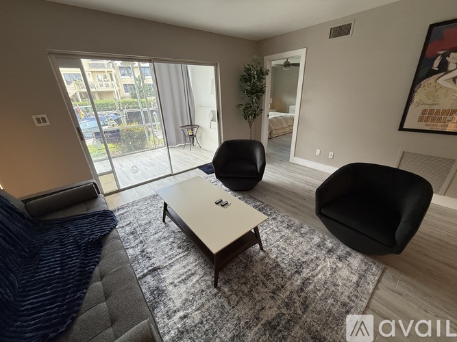 A living room with a black chair and a white coffee table.