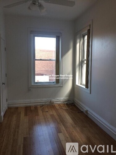 A room with wooden floors and a window showing daylight.