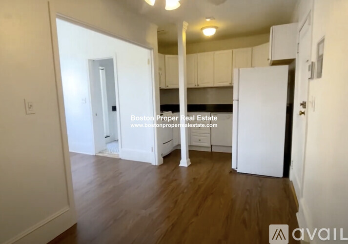 A kitchen area with white cabinets and a white refrigerator.