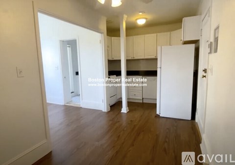 A kitchen area with white cabinets and a white refrigerator.