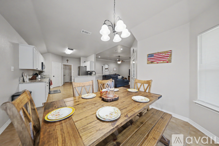 A dining room with a wooden table set for four.