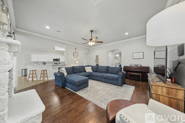 A living room with a blue couch and a wooden floor.