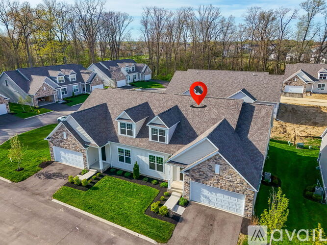 A house with a red pin on the roof is surrounded by other houses.