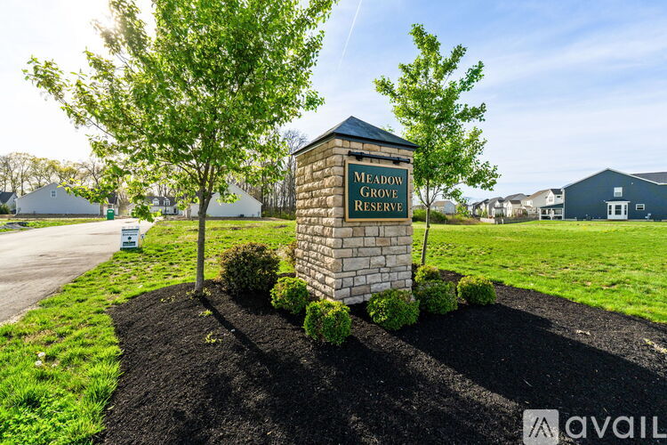 A sign for Meadow Grove Reserve stands in front of a grassy area.