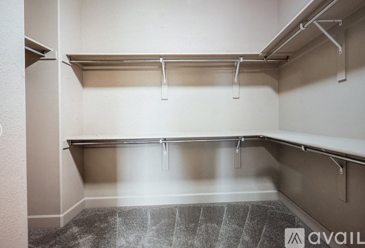 A spacious walk-in closet with shelves and a tiled floor.
