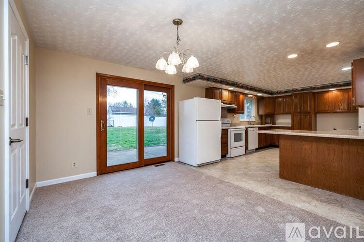 A kitchen with a white refrigerator and wooden cabinets.