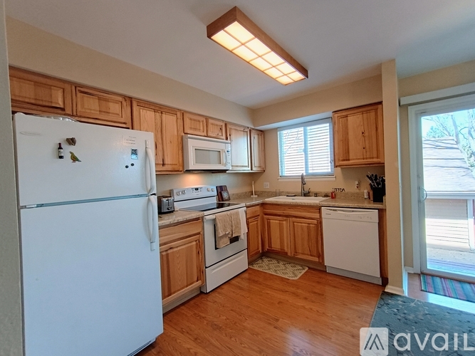 A kitchen with wooden cabinets and white appliances.
