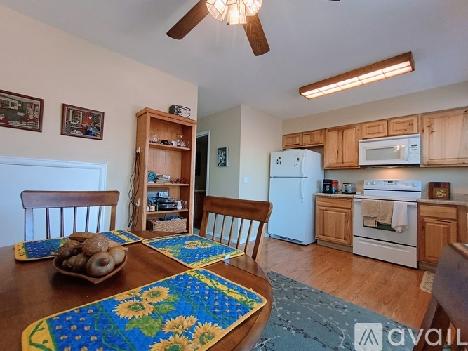 A kitchen with a table and chairs in the foreground.