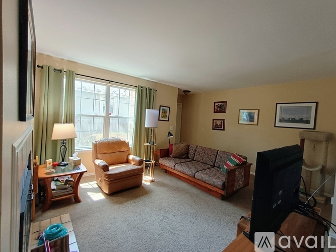 A living room with a couch, chair, and television.