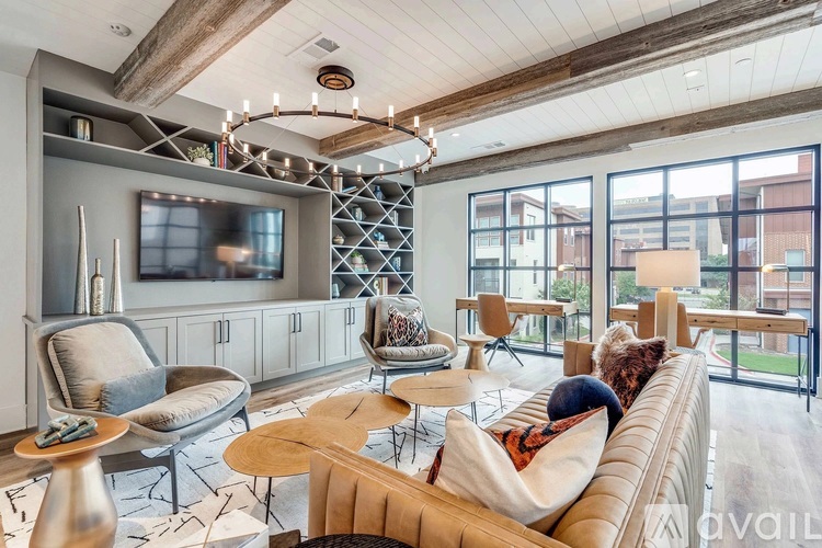 A living room with a couch, chairs, and a television.