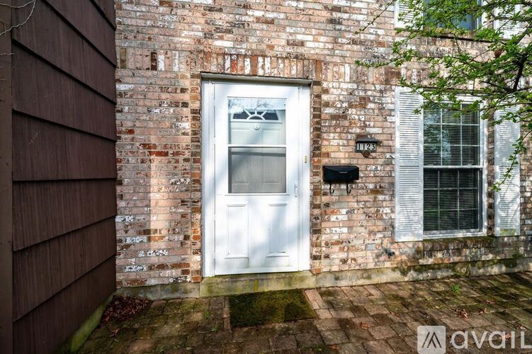 A white door is on the brick building.