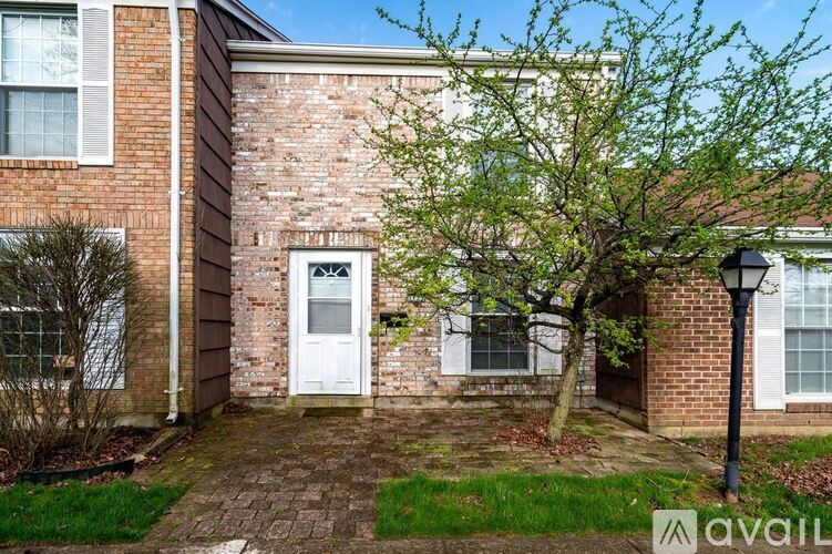 A brick house with a white door and windows.