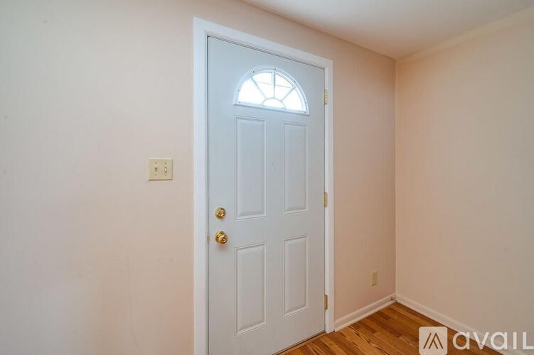 A white door with a window above it in a room.