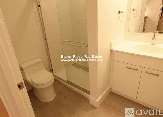 A white toilet in a bathroom with a glass shower door.