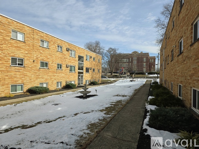 A row of brown brick apartment buildings with snow on the ground.