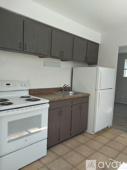 A kitchen with a white stove and a white refrigerator.