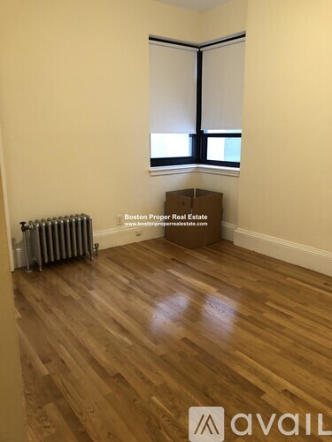 A room with wooden flooring and a window with blinds.