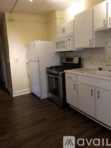 A kitchen with white appliances and cabinets.