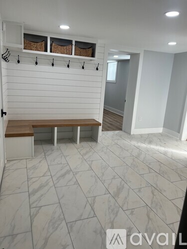 A room with a bench and hooks on the wall.