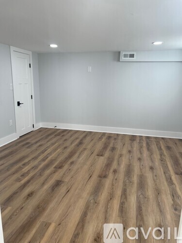 A room with wooden flooring and a white door.