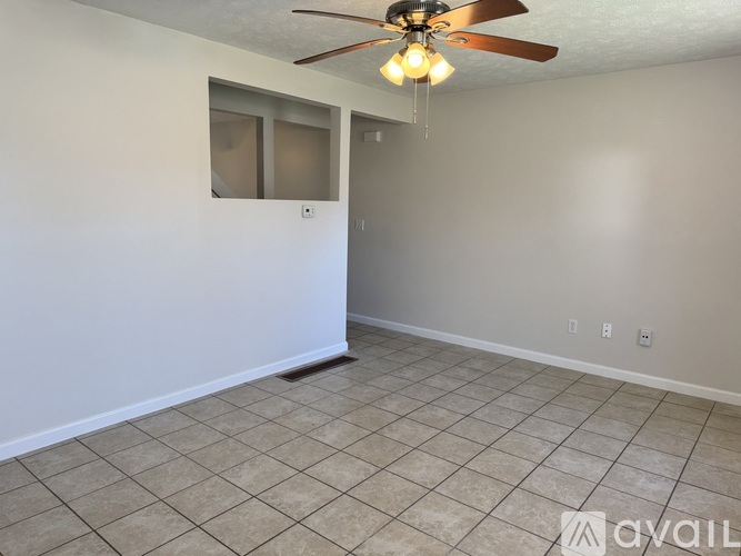 A room with a ceiling fan and tiled floor.