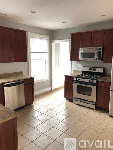 A kitchen with brown cabinets and a white stove top oven.