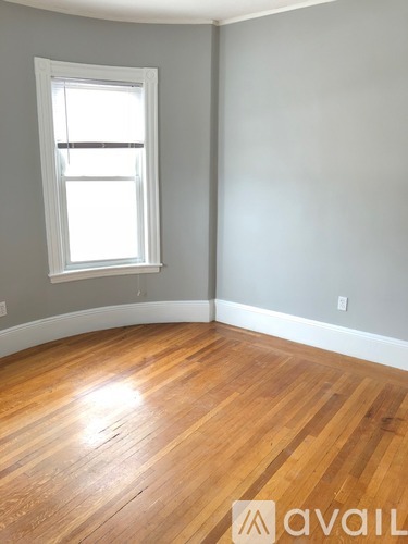 A room with wooden flooring and a window.