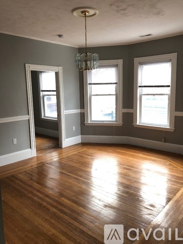 A room with wooden floors and a chandelier.