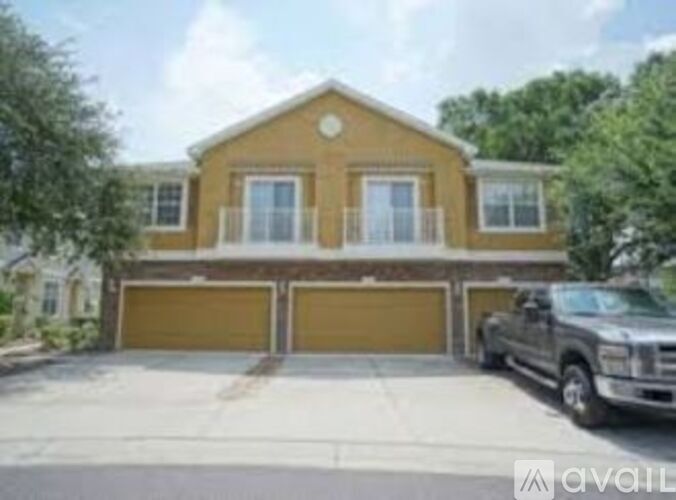 A two-story house with a garage and a truck parked in front.