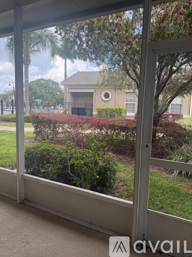 A view from inside a room looking out to a house with a tree in front.