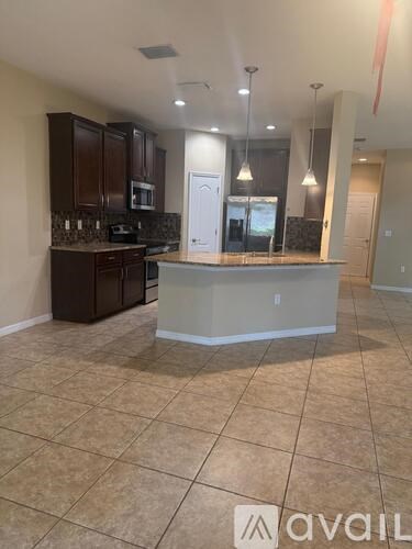 A kitchen with brown cabinets and a tiled floor.