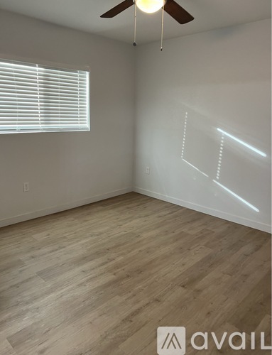 A room with wooden flooring and a ceiling fan.