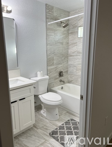A bathroom with a toilet, sink, and tub.