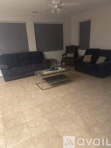 A living room with a black sofa, a grey sofa, and a coffee table.