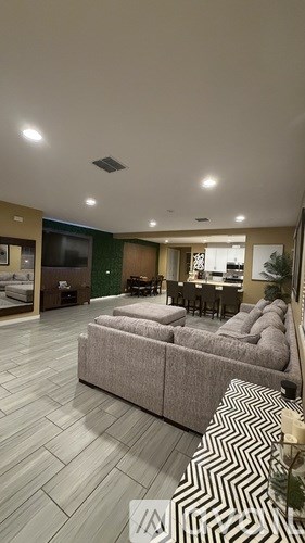 A living room with a grey sofa and a patterned rug.