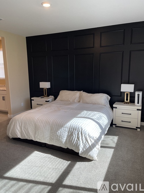 A bedroom with a large bed and two nightstands.