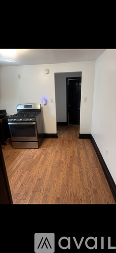 A room with wooden flooring and a black door.