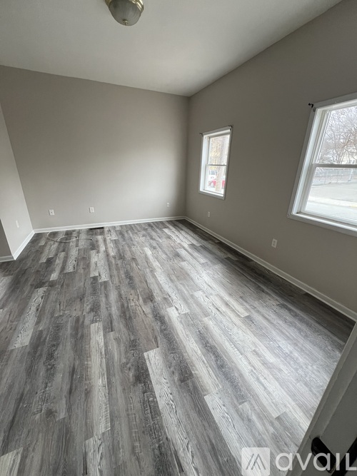 A room with wooden flooring and a window.