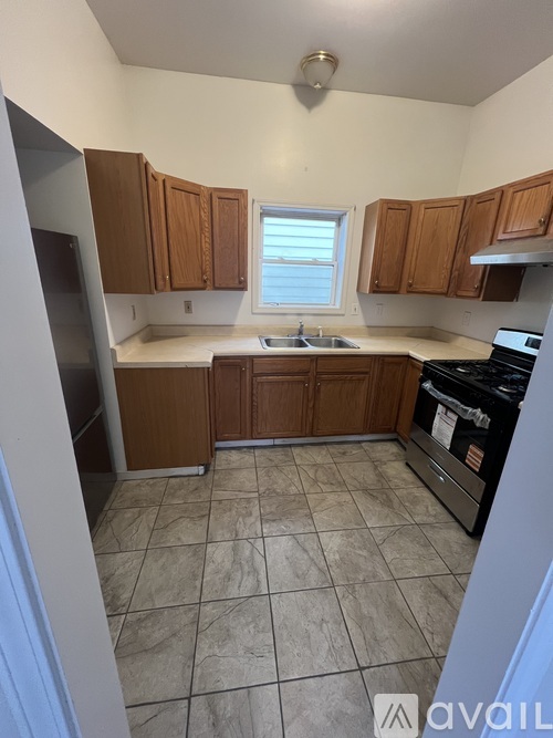 A kitchen with wooden cabinets and a tiled floor.